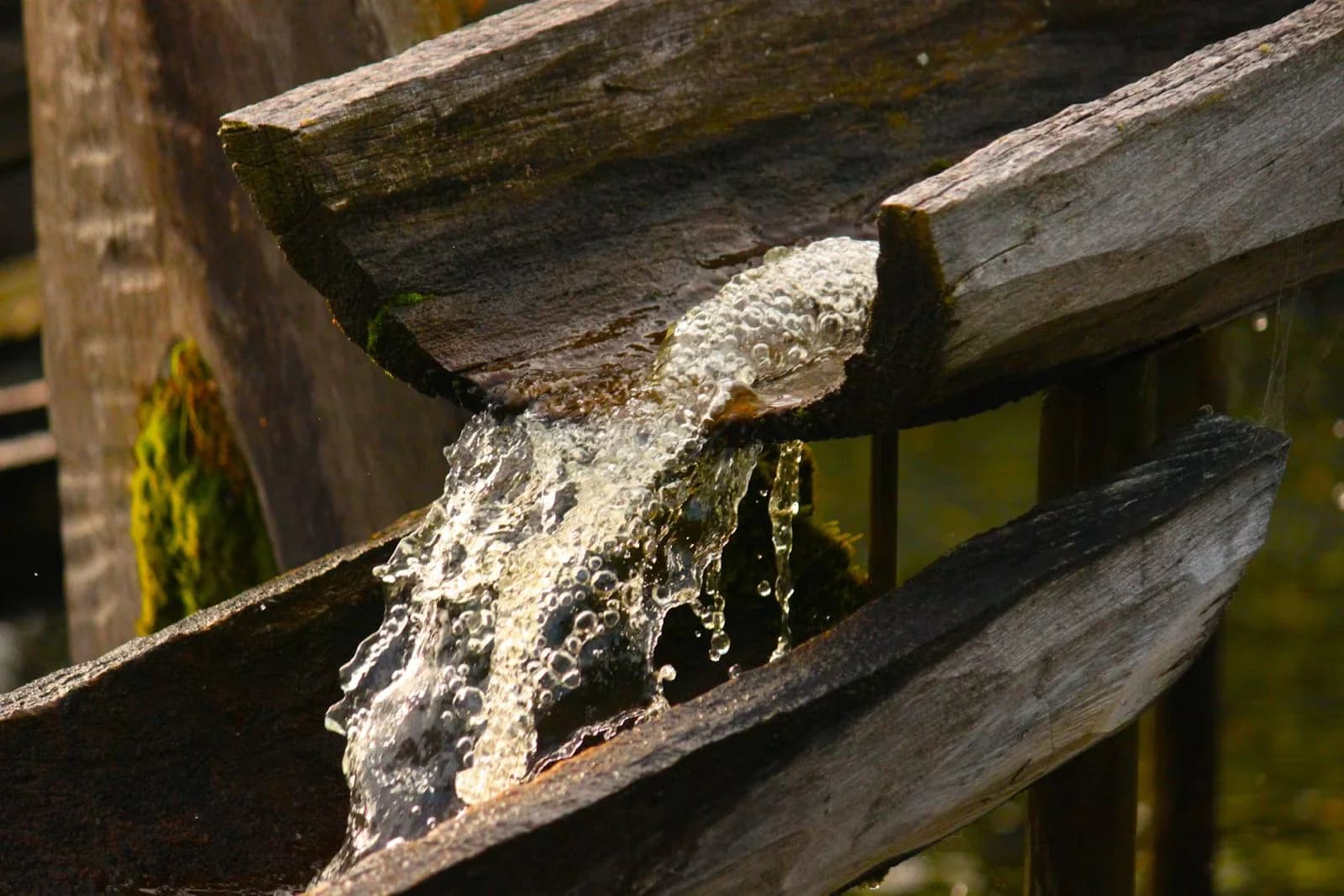 Acqua che scorre lungo una canalina di legno